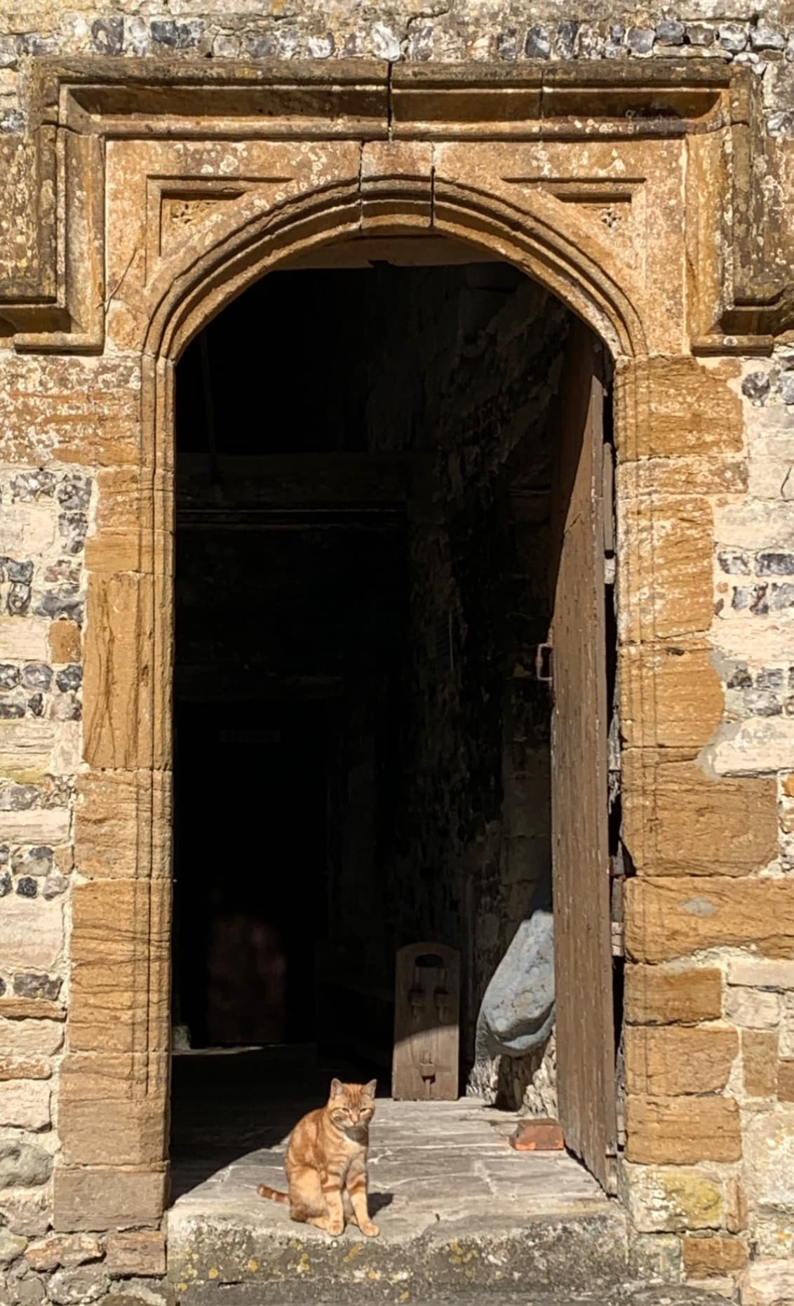 A coach group on a guided tour at Cerne Abbey in Dorset