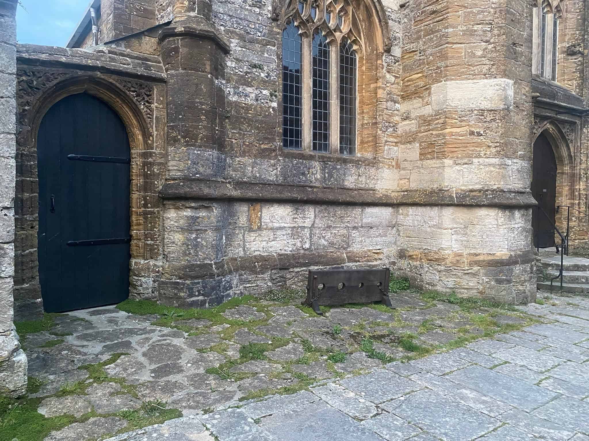 The old village stocks beside St Mary's Church in Cerne Abbas